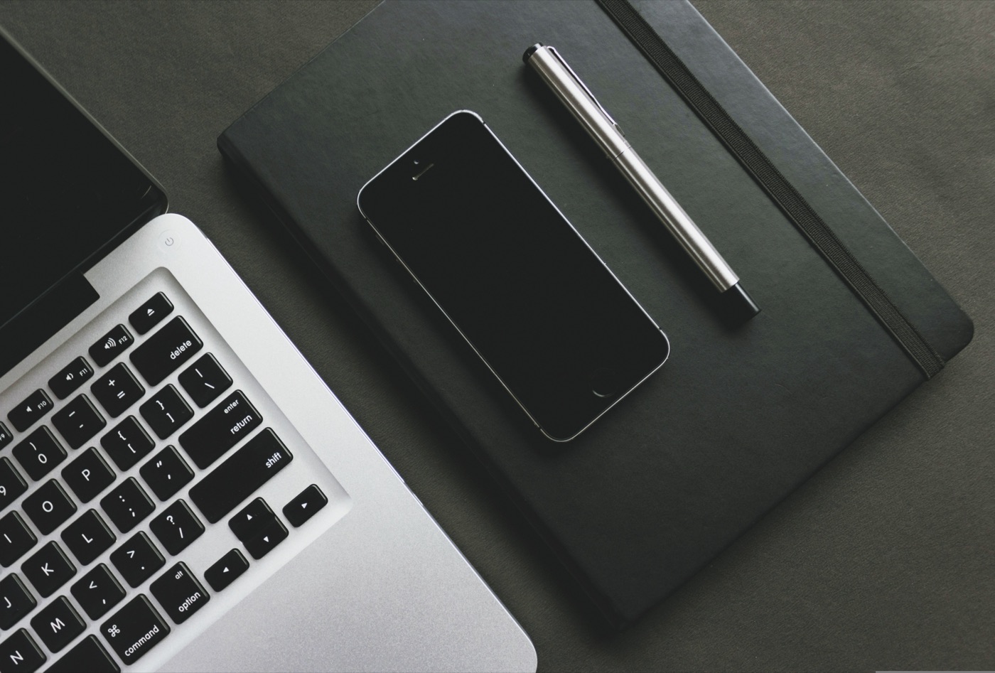 Schreibtisch mit Smartphone, Notizbuch und Stift